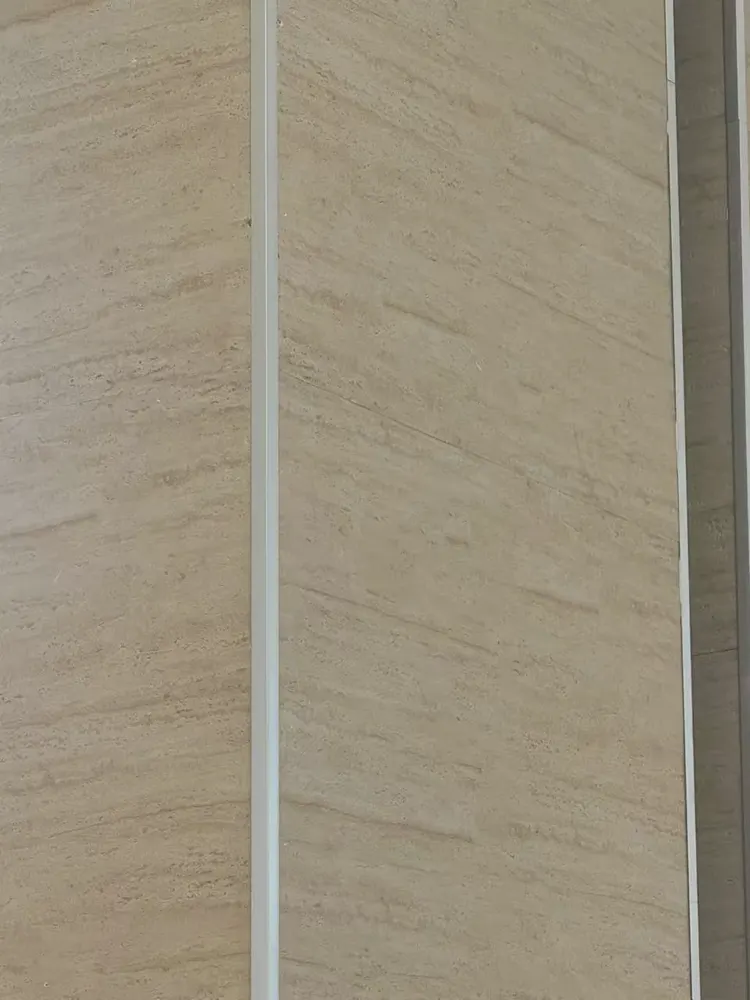 眼镜店2 · 洞石柔性石材 · 打印洞石 眼镜店2：洞石 孔洞肌理有实际起伏，斜射光下出现阴影层次，现场实拍