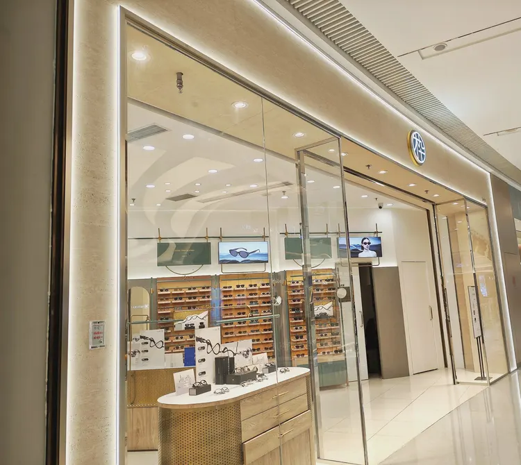 门头 · 洞石柔性石材 · 眼镜店 门头 打印洞石：洞石 孔洞肌理有实际起伏，斜射光下出现阴影层次，现场实拍