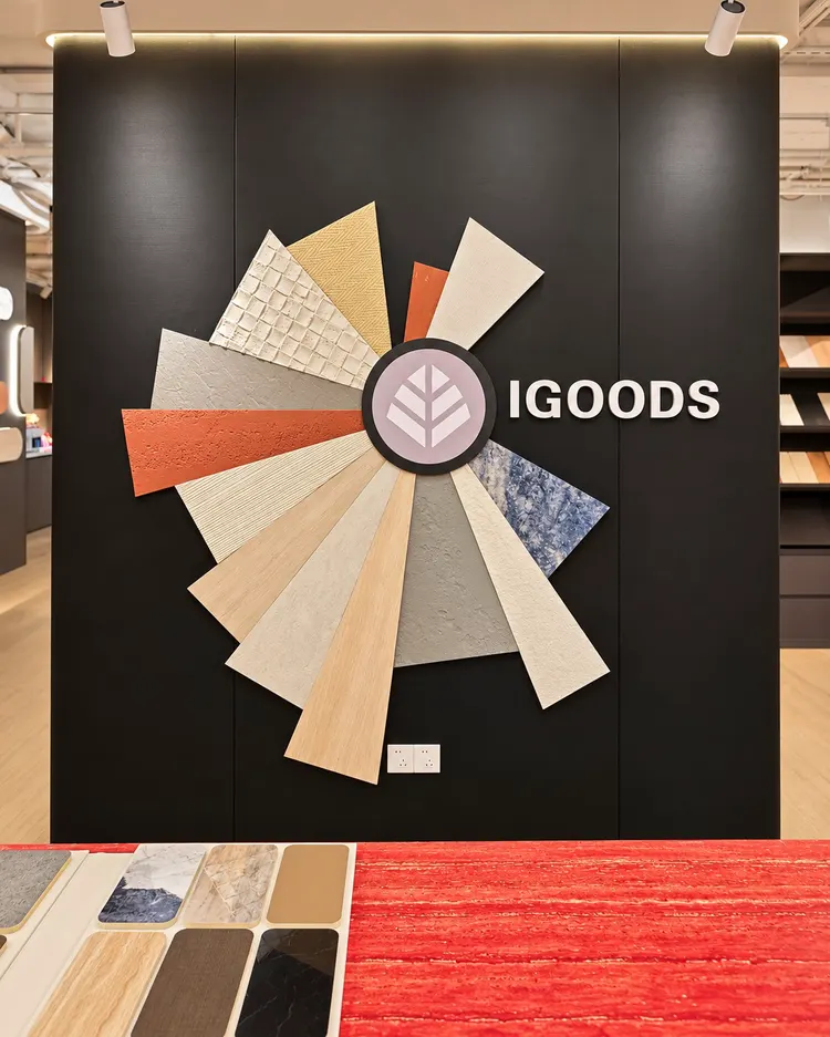 艾谷思成都展厅：IGOODS 品牌形象墙与肌理样板。黑色背景墙上，肌理样板围绕 IGOODS 标志呈放射状排布。