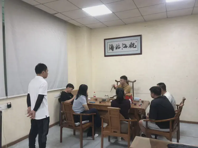 会议交流：一组人围坐会议桌交流