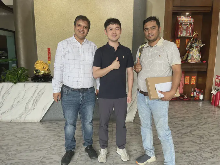 展位留念：三位人员在展位背景墙前合影
