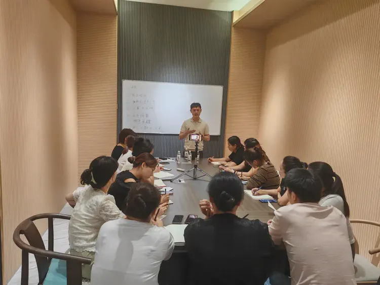 培训现场：学员分组就座，讲师在台前讲解